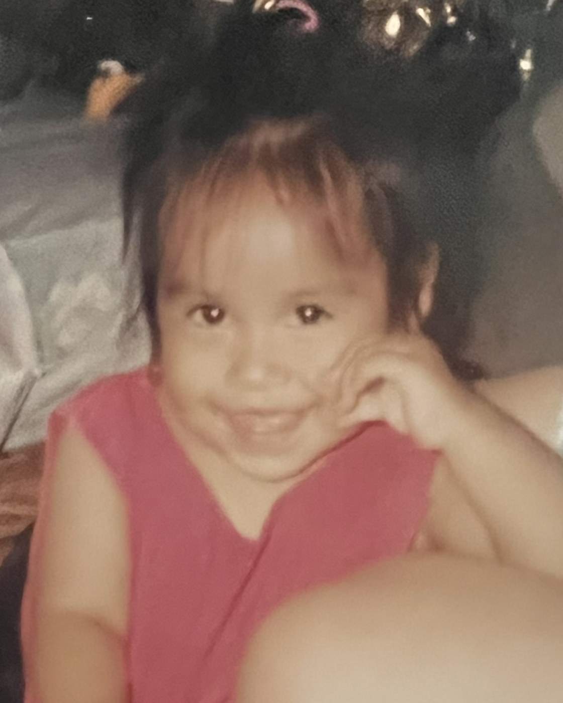 Cindy de niña, sonriendo